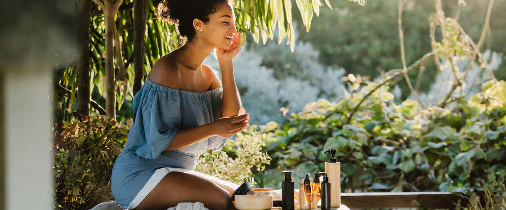 femme souriant et étalant de la crème cbd sur son visage