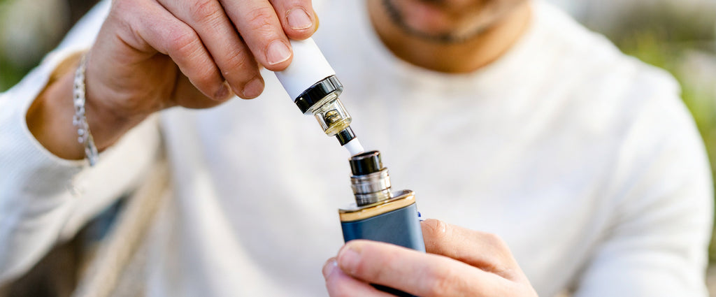 homme remplit sa vape de e liquide cbd