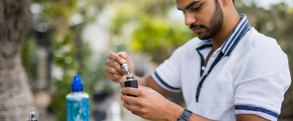 e liquide cbd inséré dans la vape par homme en blouse
